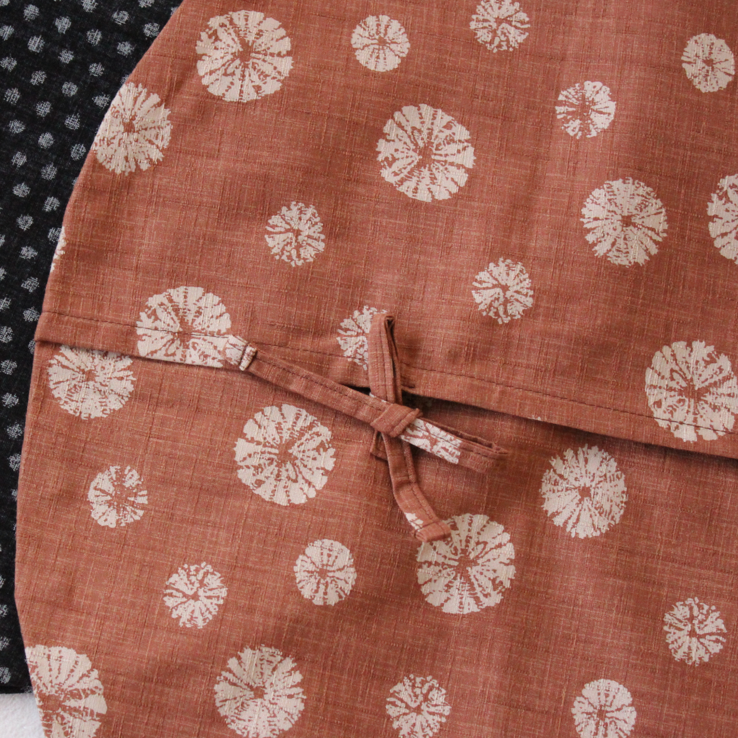 The cover features a slip-on design with an overlapping back, secured by tie closures.