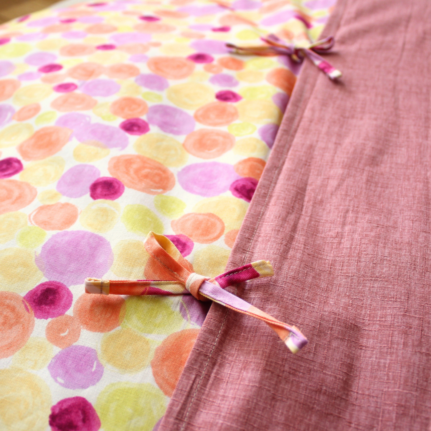 The cover features a slip-on design with an overlapping back, secured by tie closures.