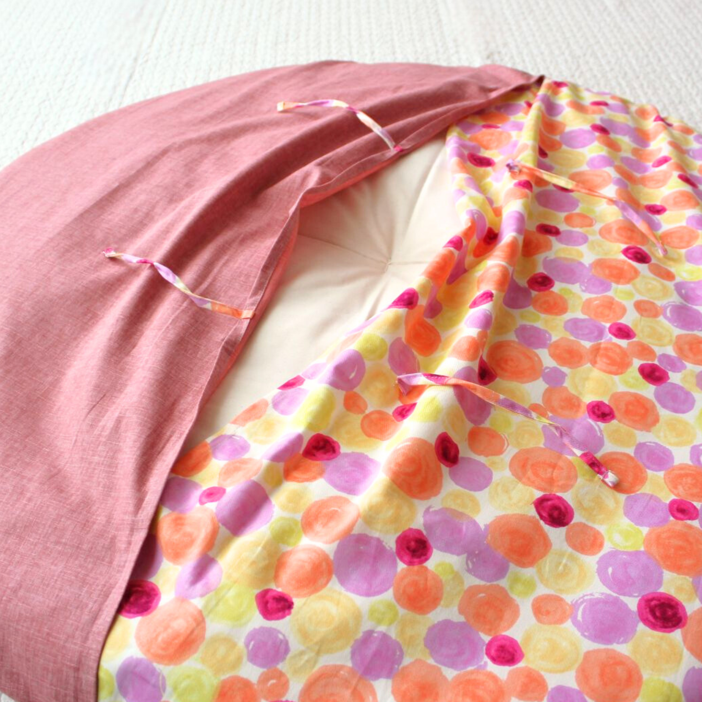 The cover features a slip-on design with an overlapping back, secured by tie closures.